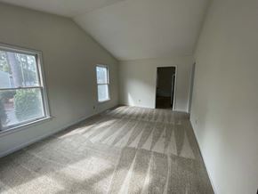 Wilson apartment for rent - A room with a carpeted floor and a door is shown.