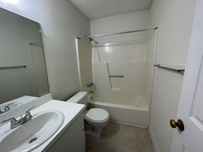 Wilson apartment for rent - A white bathroom with a toilet, sink, and bathtub.