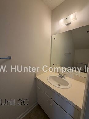 Wilson apartment for rent - A bathroom with a sink and mirror in white.