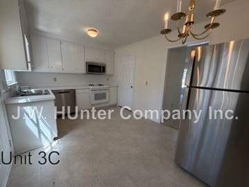 Wilson apartment for rent - A kitchen with white cabinets and a stainless steel refrigerator.