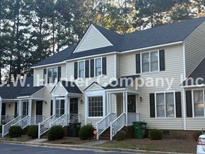 Wilson apartment for rent - A two-story house with a white front porch and black shutters.