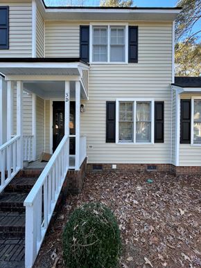 Wilson apartment for rent - A house with a white porch and black shutters.