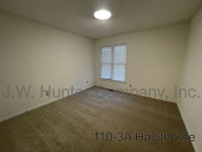 Wilson apartment for rent - A room with a carpeted floor and a window with blinds.