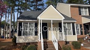 Wilson apartment for rent - A house with a white porch and a brick wall.