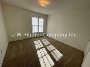 Wilson apartment for rent - A room with a carpet floor and a window letting in sunlight.