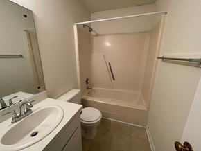Wilson apartment for rent - A white bathroom with a toilet, sink, and shower.