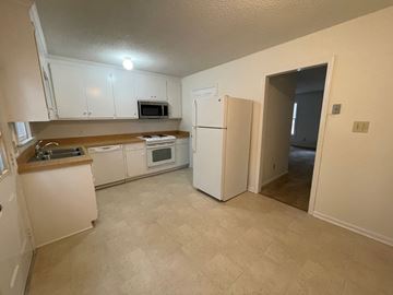 Wilson apartment for rent - A kitchen with white cabinets and appliances.