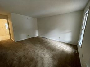 Wilson apartment for rent - A room with a carpeted floor and a window on the right side.