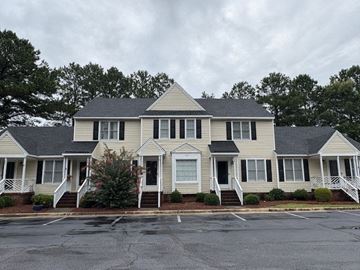 Wilson apartment for rent - A large house with a grey roof and white walls.