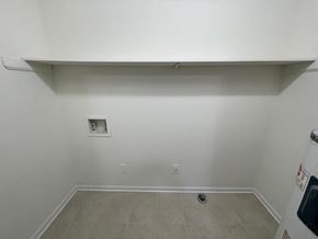Wilson apartment for rent - A white wall with a tile floor and a small square electrical outlet.