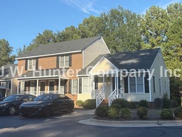 Wilson apartment for rent - Two cars parked in front of a house with the text "W Hunter company Inc" on the side.