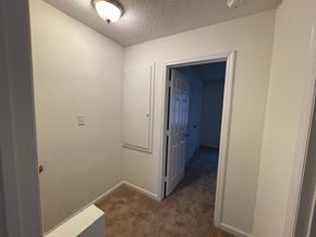 Wilson apartment for rent - A room with a white door and a brown carpet.
