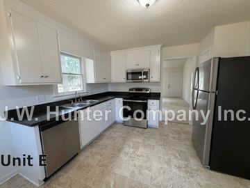 Wilson apartment for rent - A kitchen with white cabinets and a black fridge.