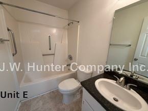 Wilson apartment for rent - A bathroom with a toilet, sink, and bathtub.
