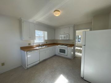 Wilson apartment for rent - A kitchen with white appliances and cabinets.