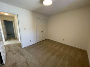Wilson apartment for rent - A room with a carpeted floor and a white door.