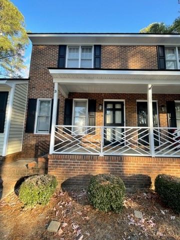 Wilson apartment for rent - A house with a white porch and black shutters.
