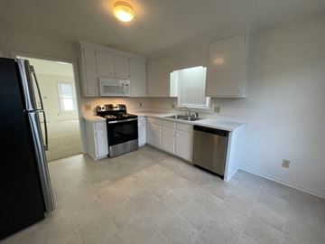 Wilson apartment for rent - A kitchen with white cabinets and a black refrigerator.