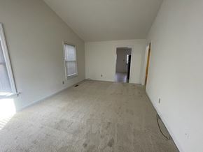 Wilson apartment for rent - A room with a carpeted floor and a doorway leading to another room.