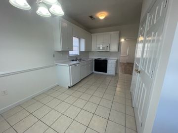Wilson apartment for rent - A kitchen with white cabinets and a white refrigerator.