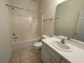 Wilson apartment for rent - A white bathroom with a toilet, sink, and bathtub.