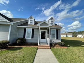 Wilson apartment for rent - A house with a grey facade and a white door is shown.