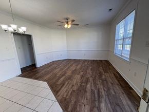 Wilson apartment for rent - A room with a ceiling fan and wooden flooring.