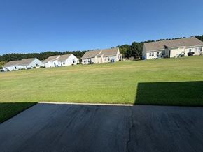 Wilson apartment for rent - A road leads to a cluster of houses in a grassy field.