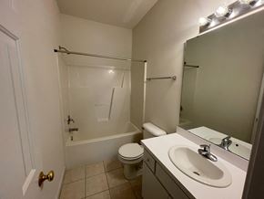 Wilson apartment for rent - A white bathroom with a toilet, sink, and bathtub.