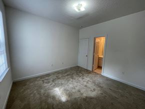 Wilson apartment for rent - A room with a carpeted floor and a doorway leading to another room.