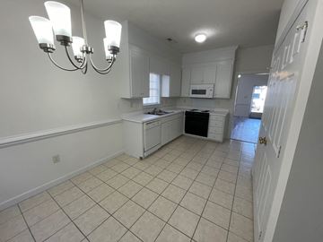 Wilson apartment for rent - A kitchen with white cabinets and a black dishwasher.