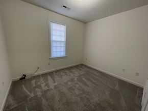 Wilson apartment for rent - A room with a carpeted floor and a window.