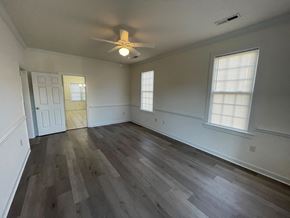 Wilson apartment for rent - A room with a ceiling fan and wooden flooring.