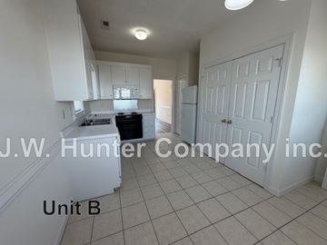 Wilson apartment for rent - A kitchen with white cabinets and a white refrigerator in a white room.