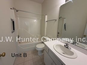 Wilson apartment for rent - A bathroom with a white toilet, sink and shower.
