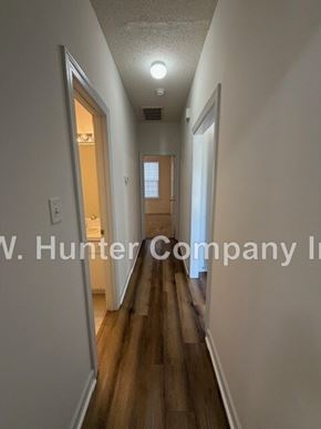 Wilson apartment for rent - A long hallway with wood floors and white walls.