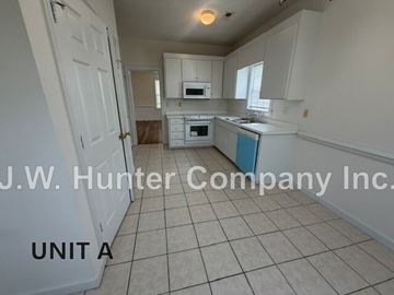 Wilson apartment for rent - A kitchen with white cabinets and a blue trash can.