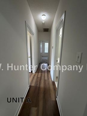 Wilson apartment for rent - A long hallway with wood floors and white walls.