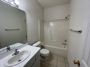 Wilson apartment for rent - A white bathroom with a toilet, sink, and bathtub.