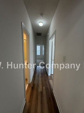 Wilson apartment for rent - A long hallway with a light on the ceiling and a door on the right.