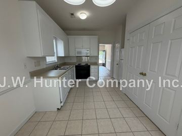 Wilson apartment for rent - A kitchen with white cabinets and a tiled floor.