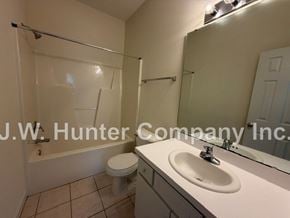 Wilson apartment for rent - A white sink in a bathroom with a white toilet and a glass shower door.