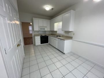 Wilson apartment for rent - A kitchen with white cabinets and appliances.