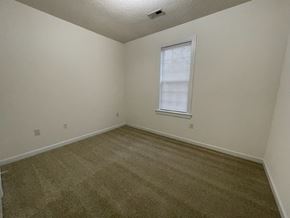 Wilson apartment for rent - A room with a carpeted floor and a window with blinds.
