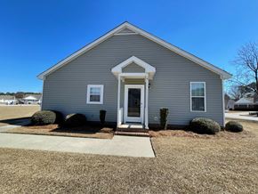 Wilson apartment for rent - A small house with a grey exterior and a white door.