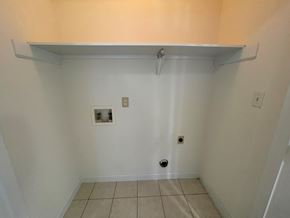 Wilson apartment for rent - A white wall with a small electrical outlet and a vent.