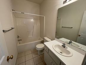 Wilson apartment for rent - A white bathroom with a toilet, sink, and bathtub.