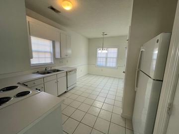 Wilson apartment for rent - A kitchen with white appliances and a white tile floor.