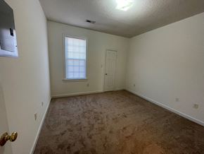 Wilson apartment for rent - A room with a carpeted floor and a door.