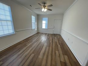Wilson apartment for rent - A room with wooden flooring and a ceiling fan.